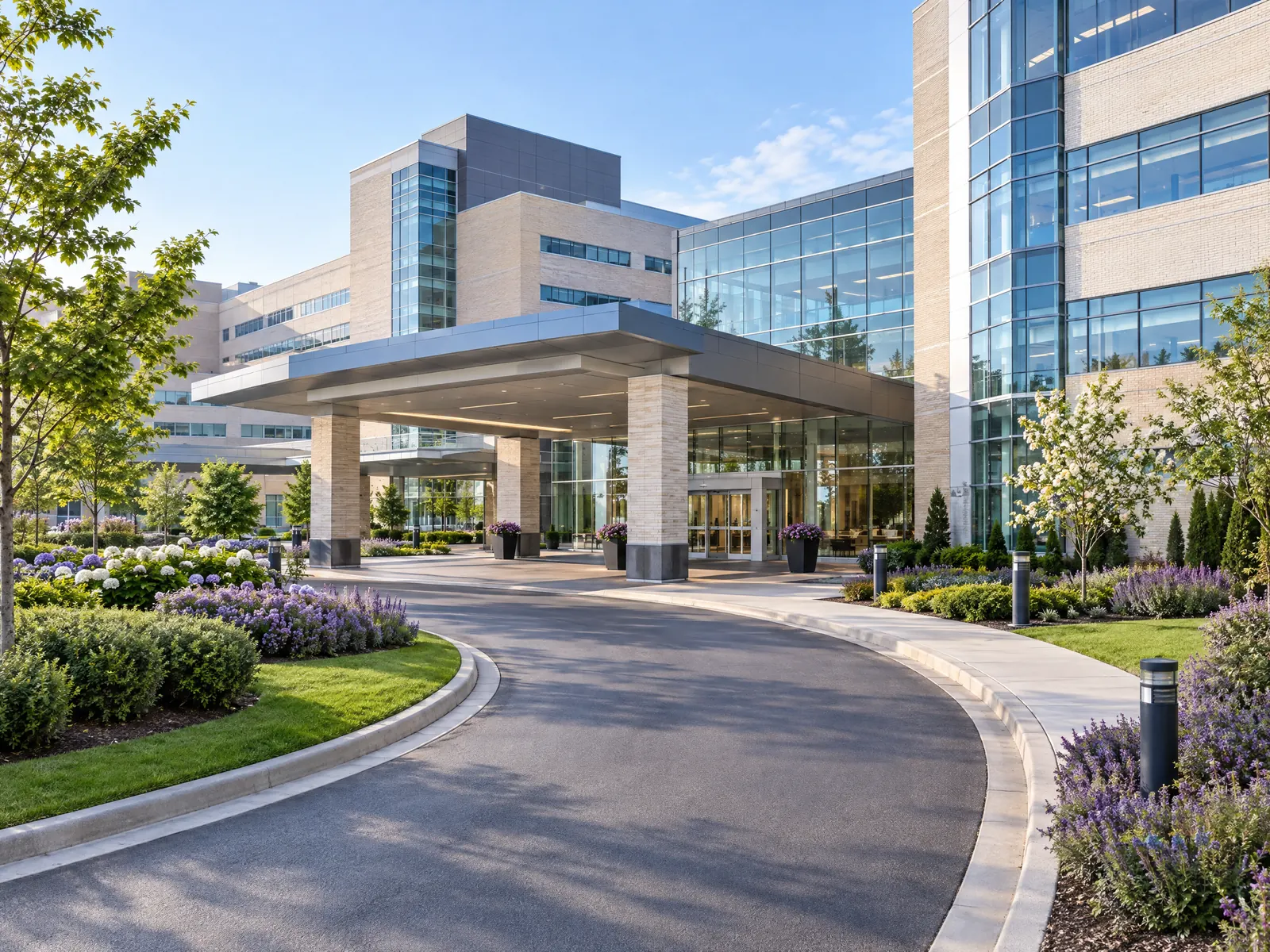 Modern hospital campus with a covered entrance drive and landscaped lawns